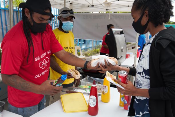 Hardworking and cheerful staff of Media Partners happily serving one of the supportive fans of Team PNG that visited the Kiosk and purchased last Friday 30th April, 2021.