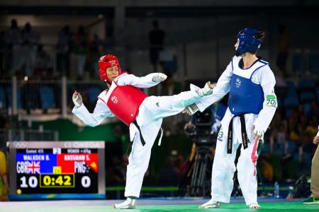 SIDE KICK: Samantha Kassman (in red) launching an attack on Bianca Walkden in their +67kg competition in women's Taekwondo. PHOTO: J. Pini/ Team PNG.